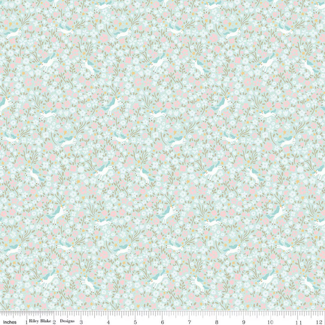 A repeating fabric pattern featuring white rabbits and pink and white flowers on a light blue background, shown with a ruler along the bottom edge indicating scale.