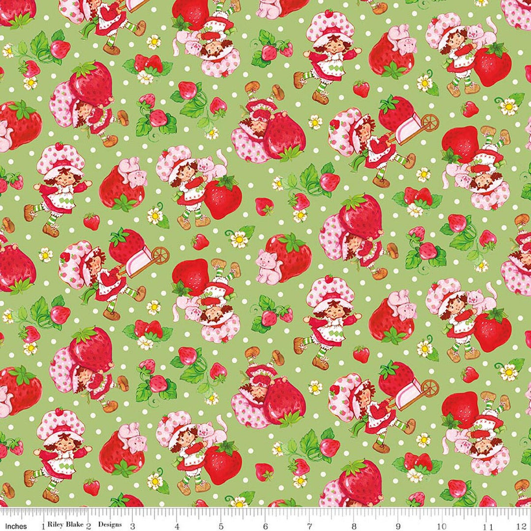 Fabric pattern with cartoon characters, strawberries, and polka dots on a green background.