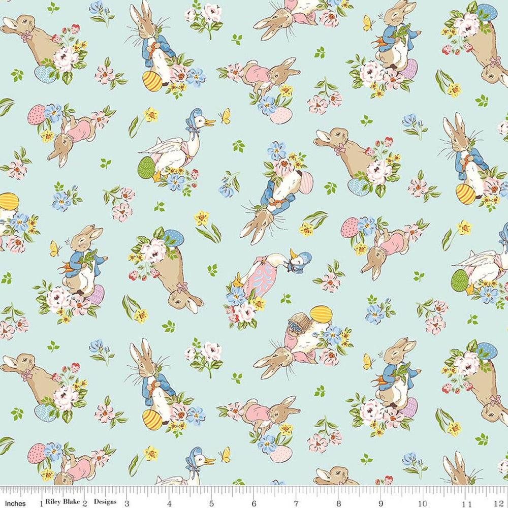 Pattern of cartoon bunnies and flowers on a light blue background with a ruler at the bottom for scale