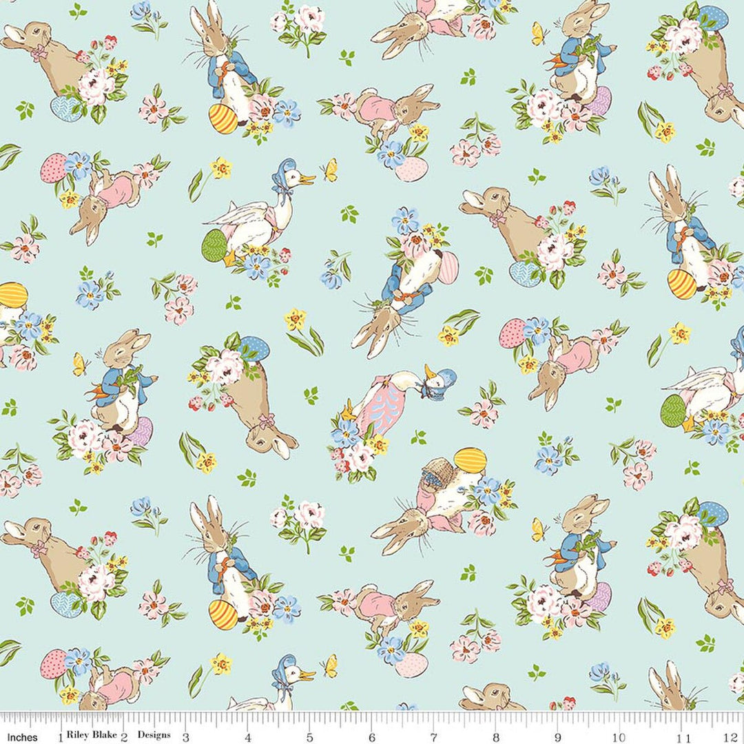 Pattern of cartoon bunnies and flowers on a light blue background with a ruler at the bottom for scale