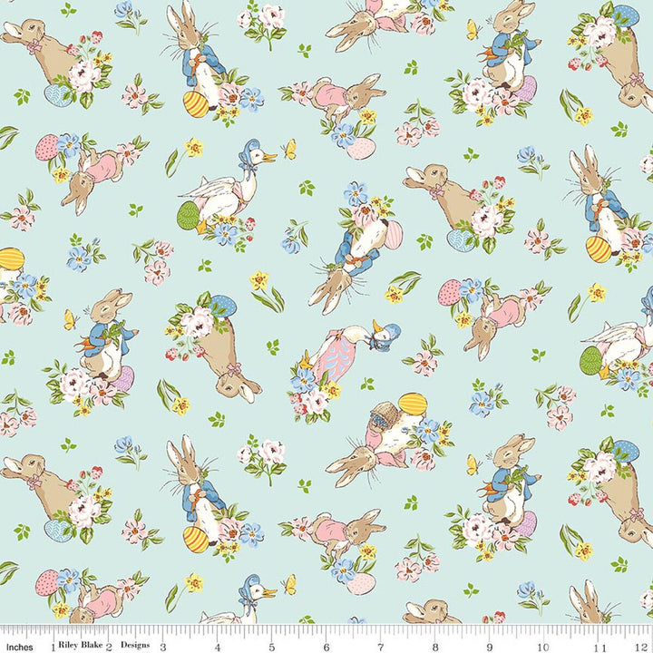 Pattern of cartoon bunnies and flowers on a light blue background with a ruler at the bottom for scale