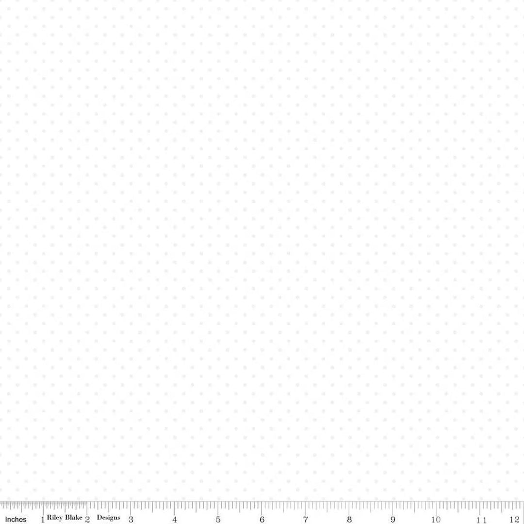 White fabric with small black dots and a ruler at the bottom for scale.