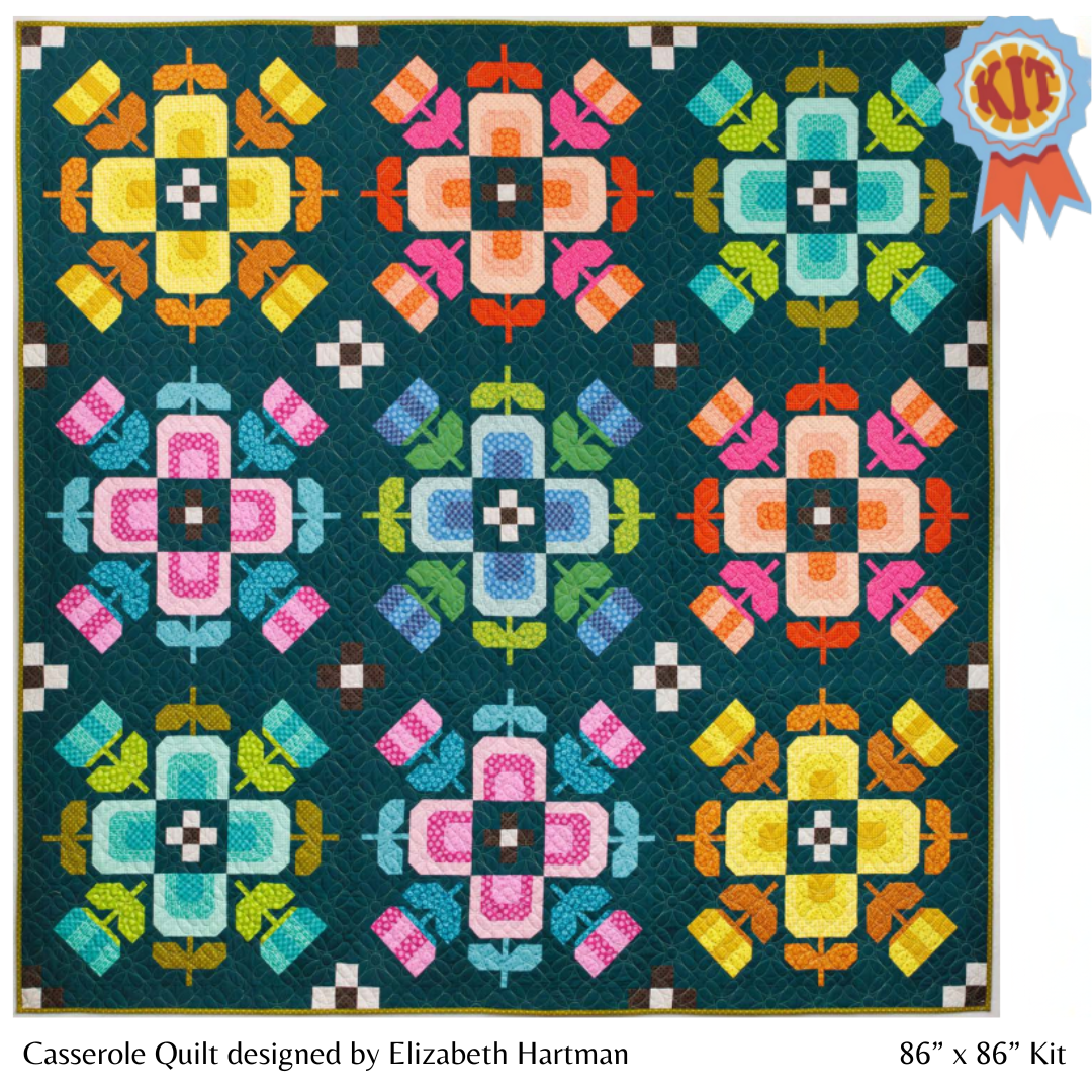 Colorful quilt pattern with geometric design on a blue background, featuring a 'Kit' label.