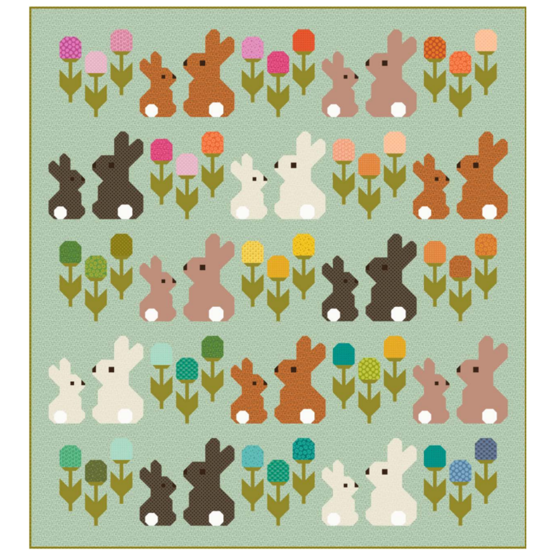 Quilt with bunnies and flowers on a light green background