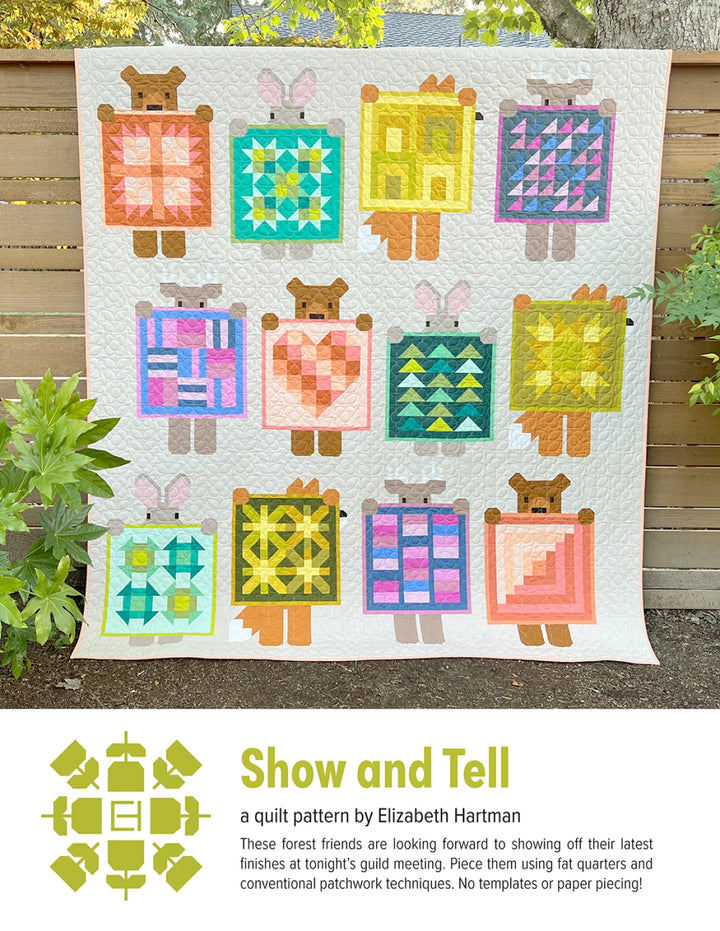 Colorful quilt with bear and rabbit designs displayed outdoors.