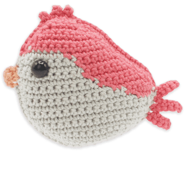 Crocheted fish toy with pink top and gray bottom on a transparent background