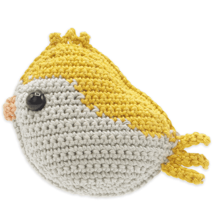 Crocheted fish toy with yellow and gray body on a transparent background