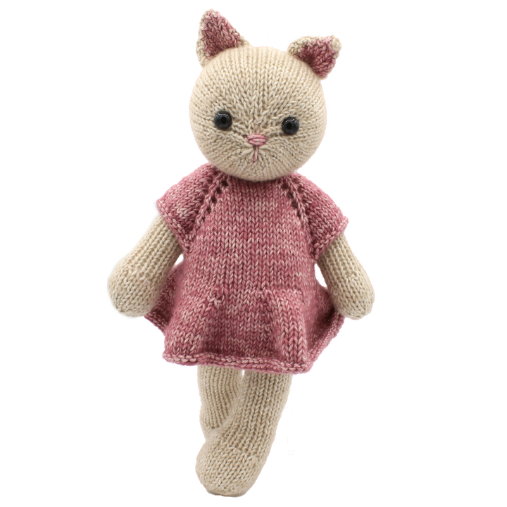 Knitted cat toy with a pink dress on a white background