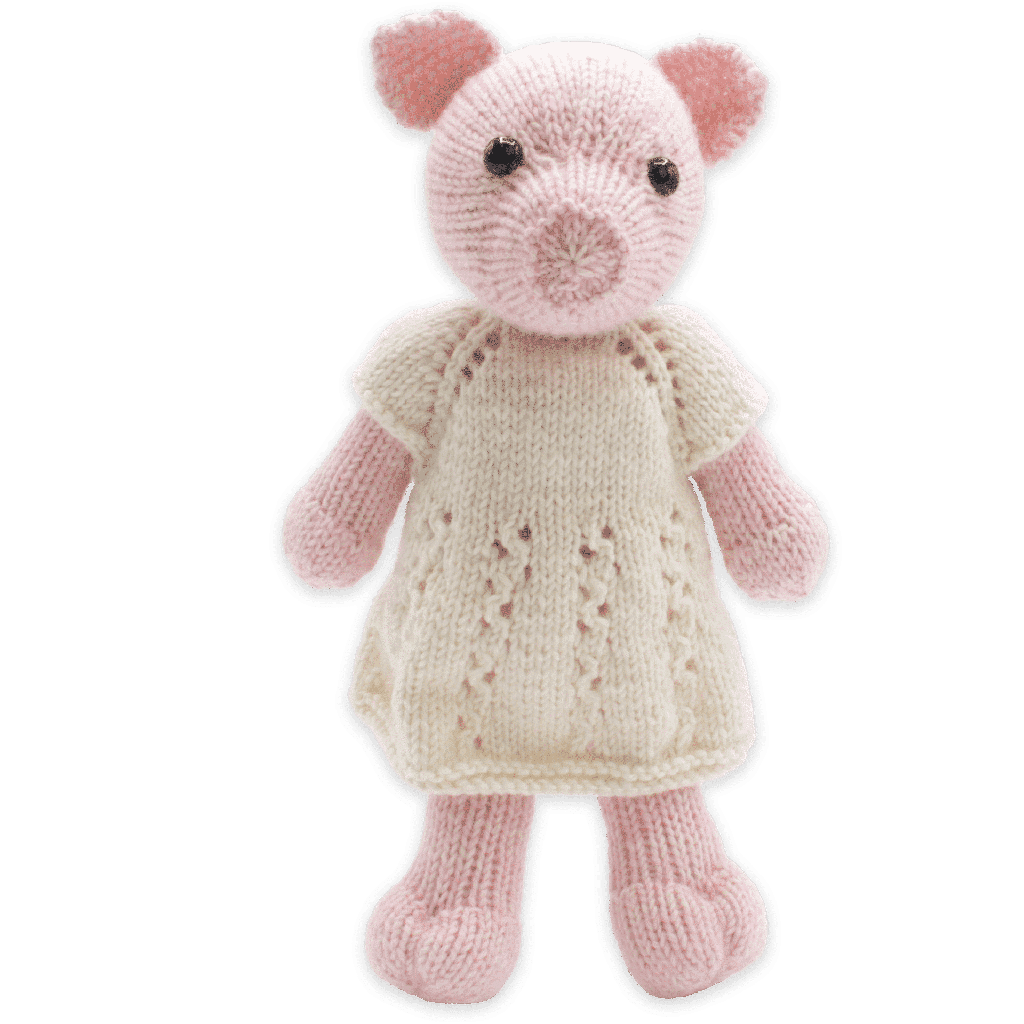 Knitted toy pig wearing a white dress on a green background