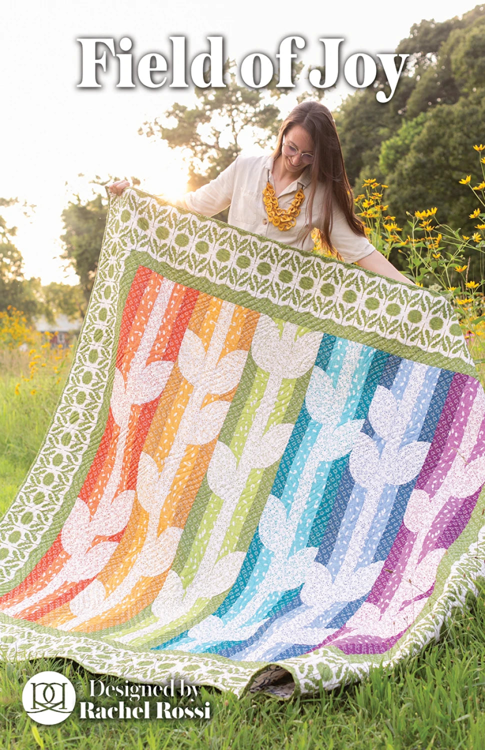 Woman holding a colorful quilt with floral patterns in a natural setting
