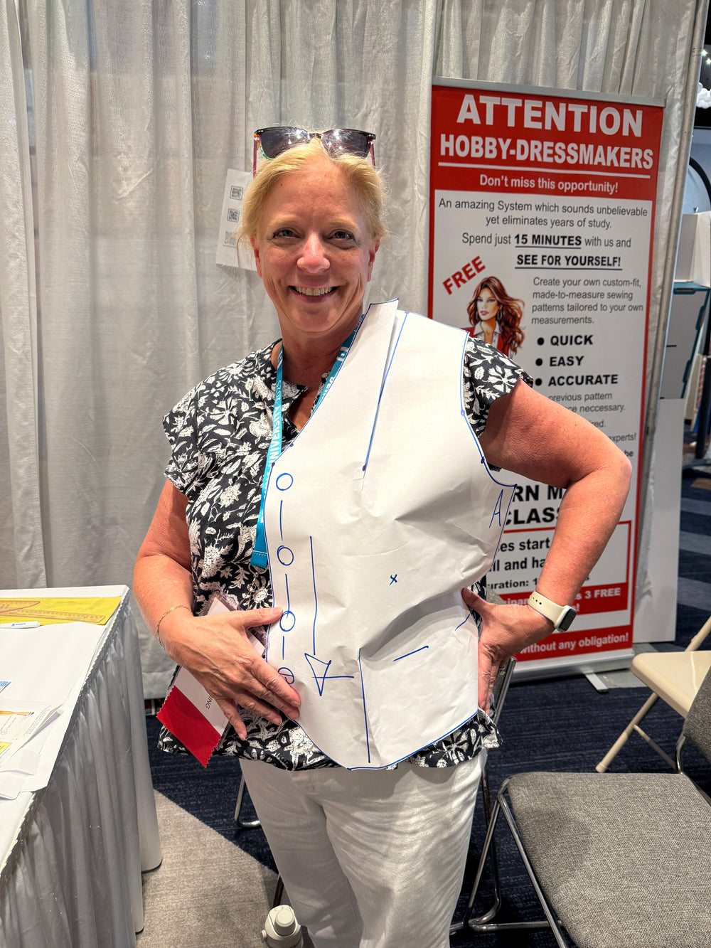 Person wearing a white apron with blue markings in an indoor setting.