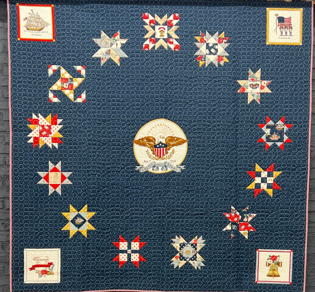 Quilt with star patterns and a central emblem on a blue background