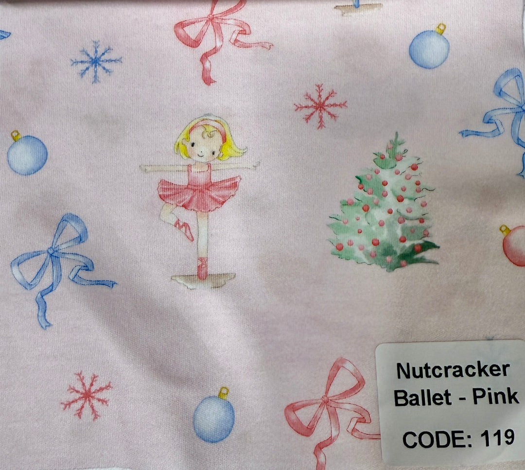 Fabric with Christmas-themed design featuring a ballerina, tree, and ornaments on a light background.