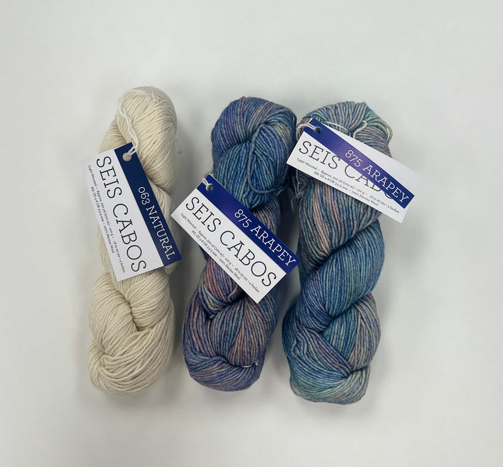 Three skeins of yarn with labels on a white background