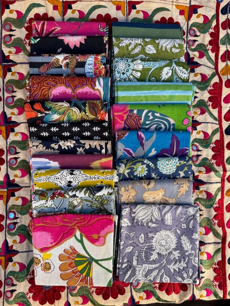 Collection of folded fabric swatches arranged in a grid on a colorful patterned background