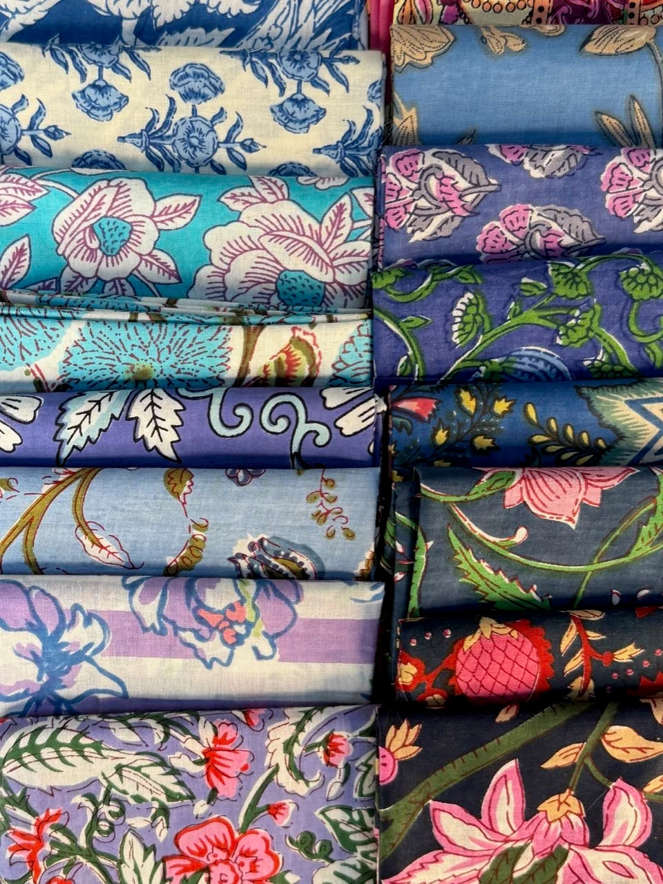 Stack of colorful fabric rolls with floral patterns