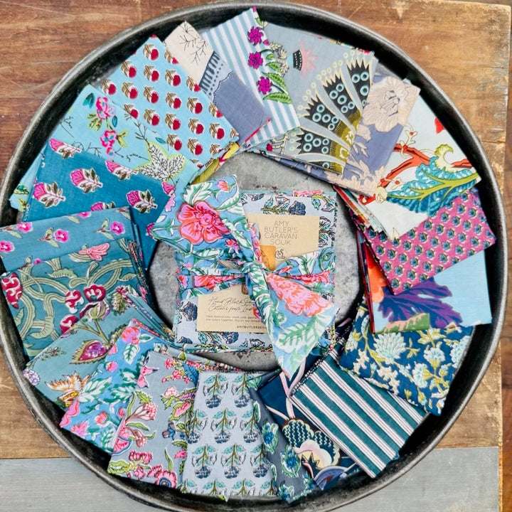 Collection of colorful fabric swatches arranged in a circular pattern on a wooden surface.