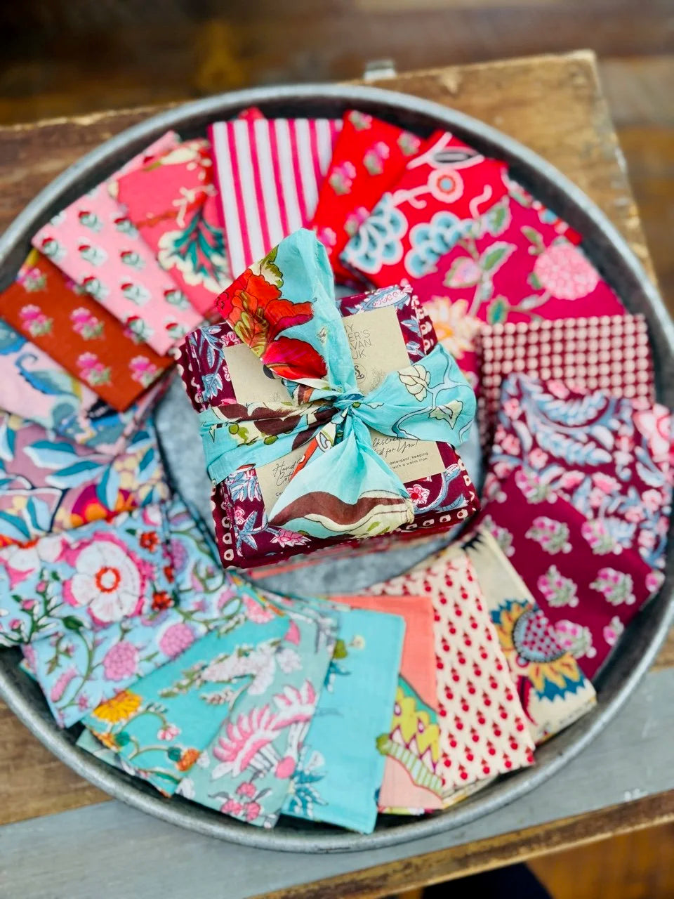 Collection of colorful fabric squares in a metal tray