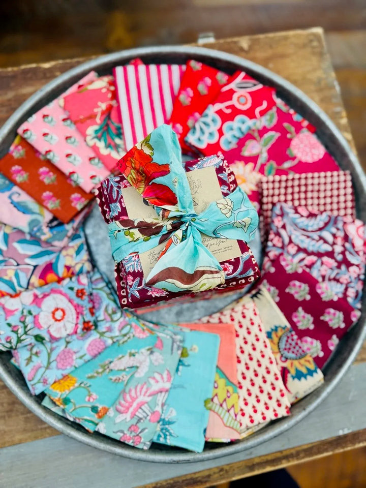 Collection of colorful fabric squares in a metal tray