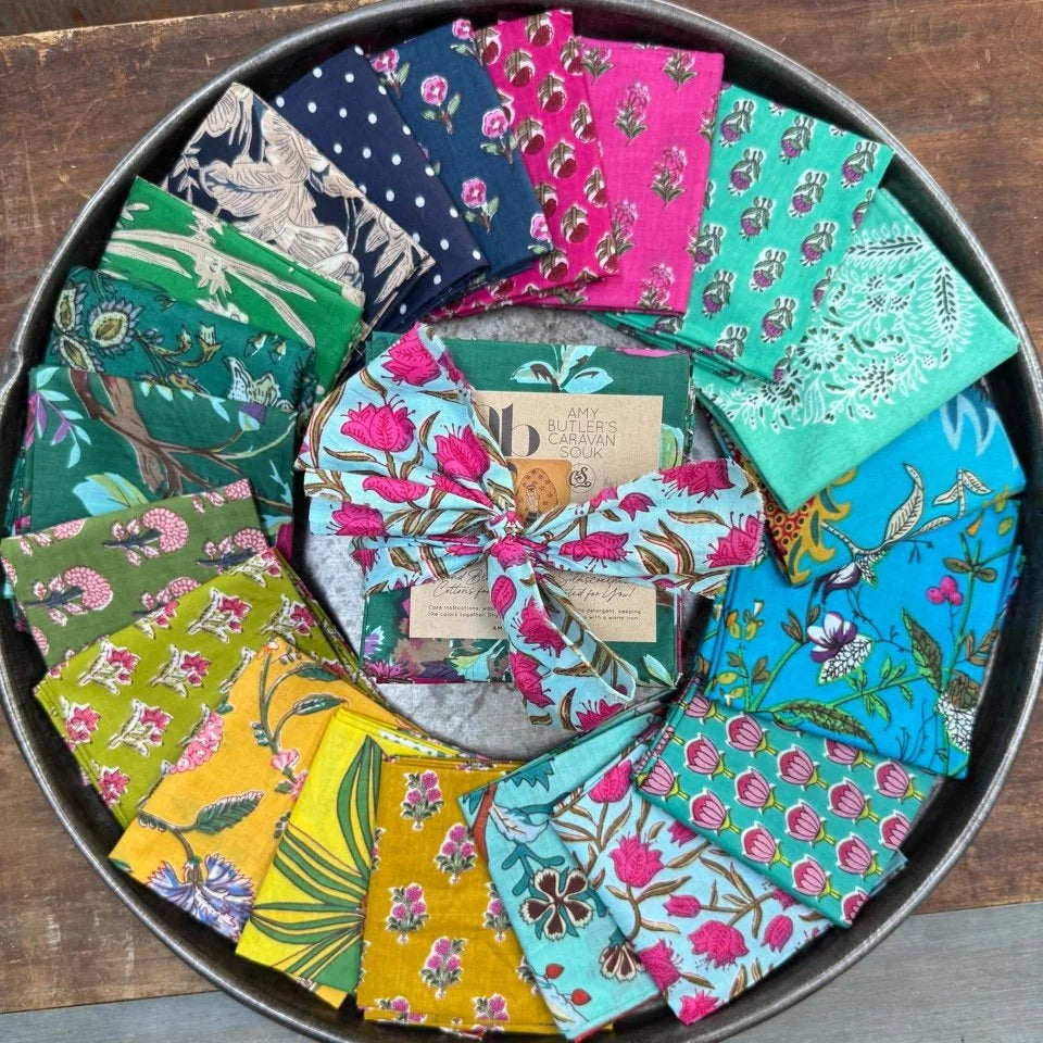 Collection of colorful fabric swatches arranged in a circular pattern on a wooden surface.