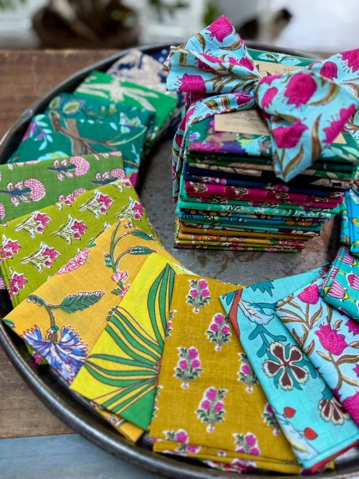Stack of colorful fabric squares on a metal tray