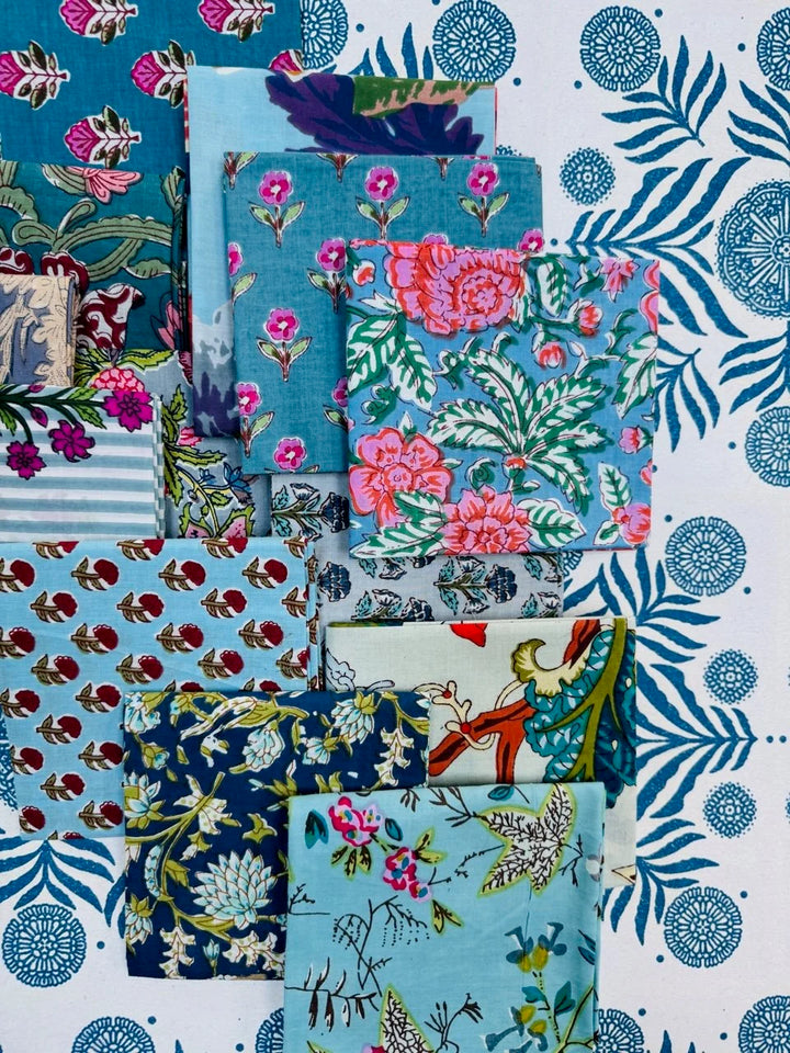Collection of colorful fabric swatches with floral and abstract patterns on a blue and white background.