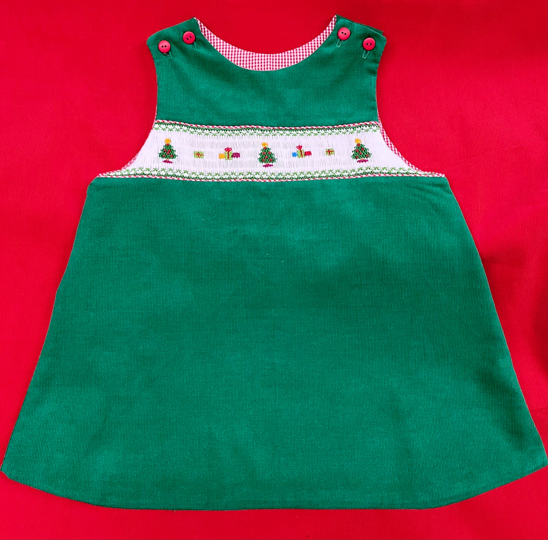 picture of Christmas trees and presents on a smocked insert in a green a-line jumper with a red background