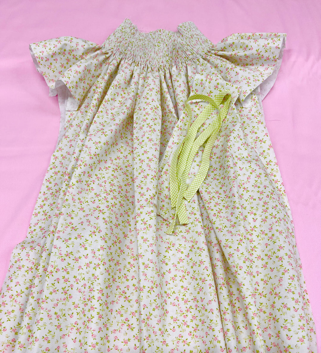 pink and green floral pleated bishop laying on a pink background