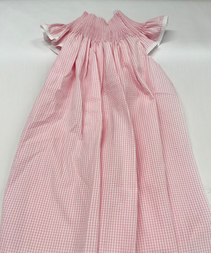 pleated pink gingham bishop dress on a white background