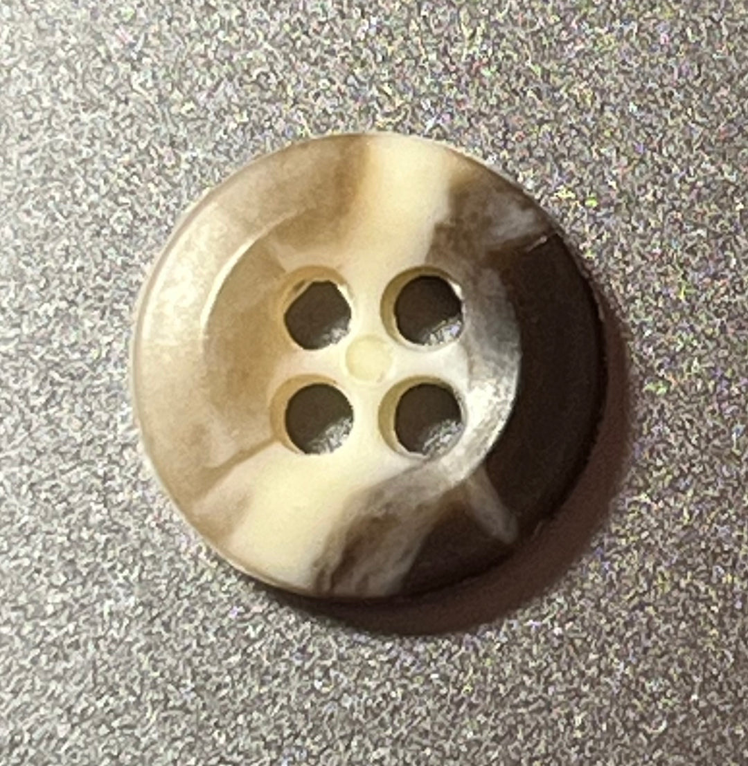 Round button with four holes on a textured gray background