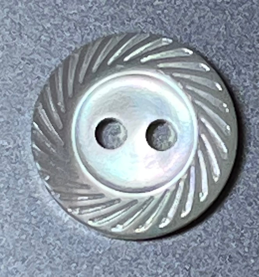 Pearl button with a textured design on a gray background
