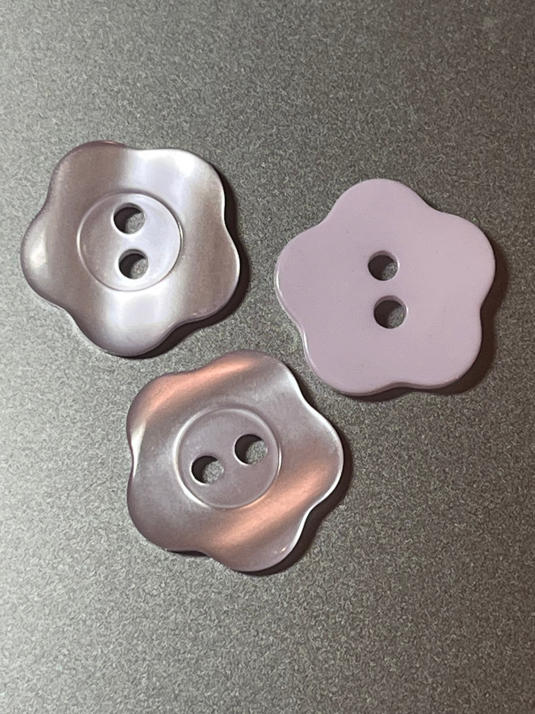 Three lavender blue buttons on a gray background