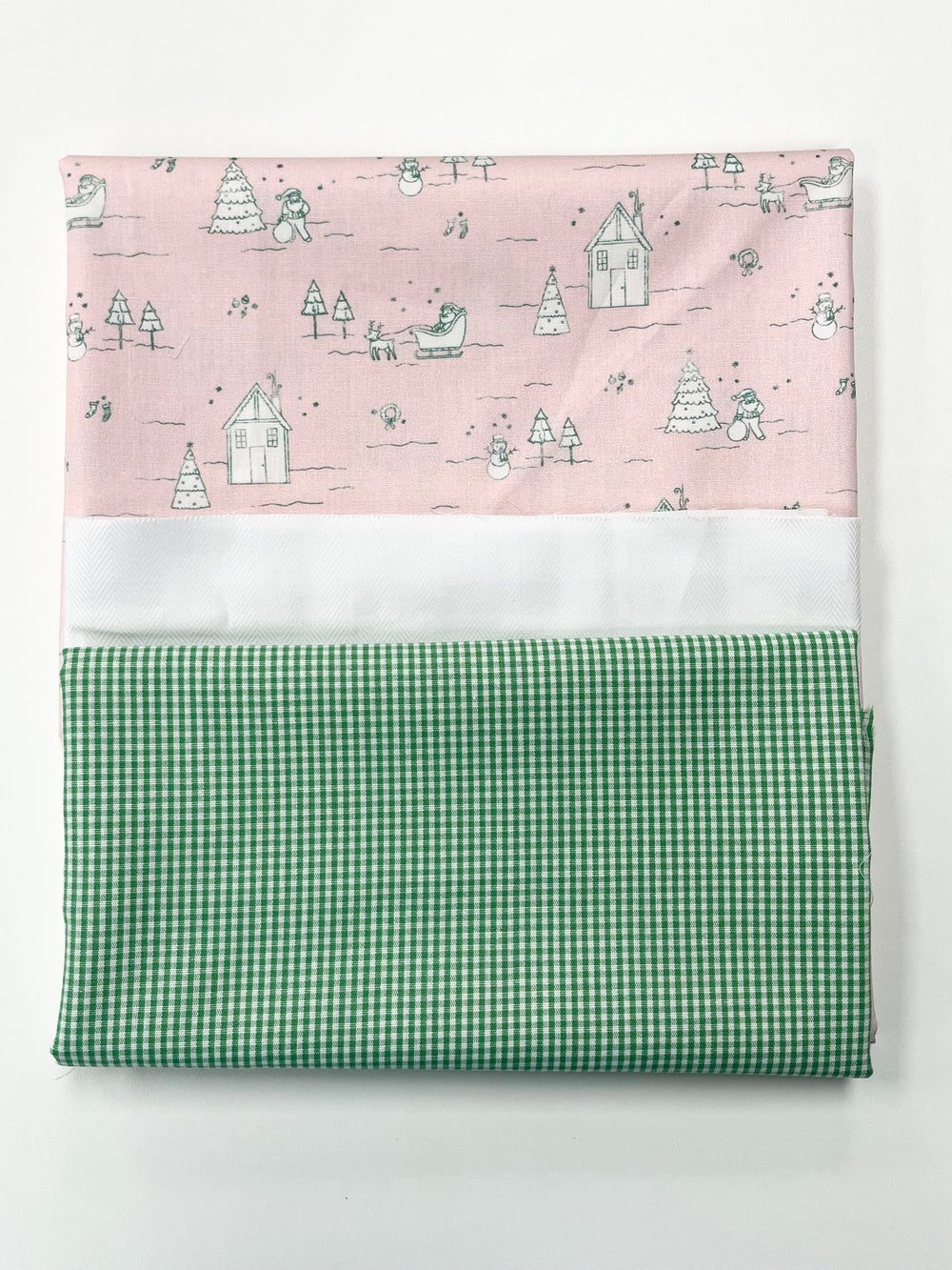 Fabric swatch with pink patterned top and green checkered bottom on a white background