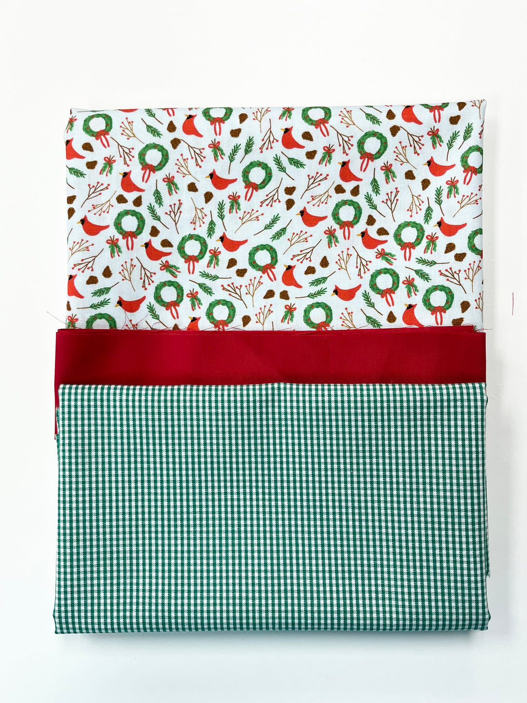 Festive fabric with Christmas pattern and green checkered border on a white background