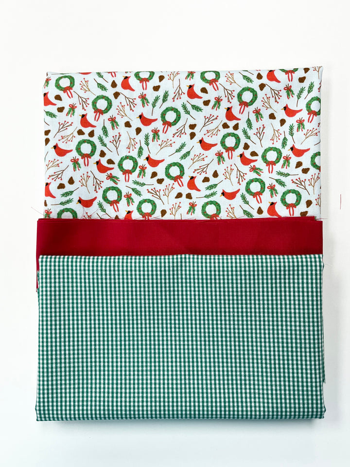 Festive fabric with Christmas pattern and green checkered border on a white background