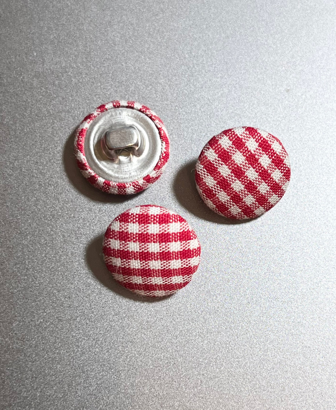 red gingham covered buttons on agrey background