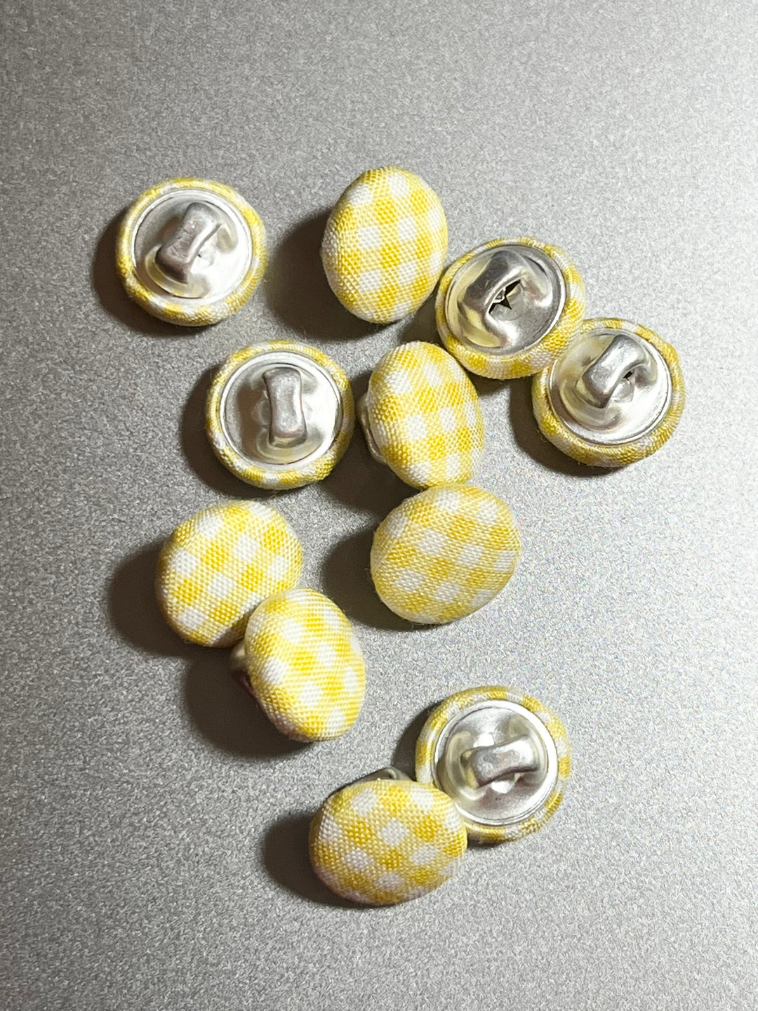 yellow gingham covered buttons on a grey background