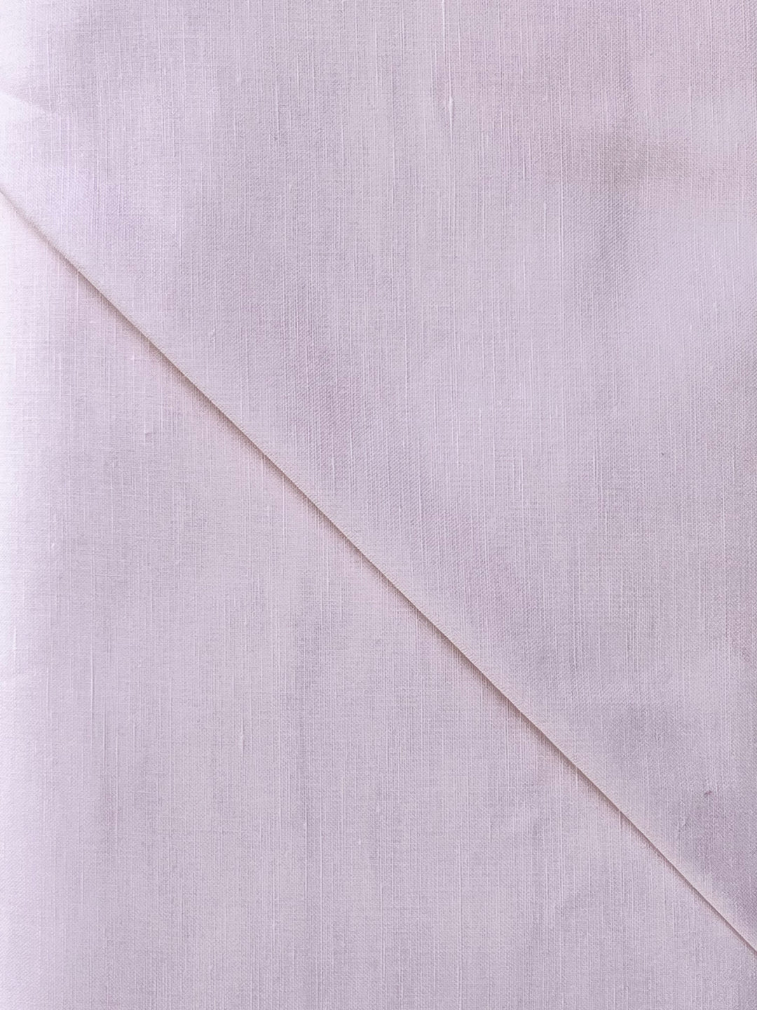 Close-up of a light pink fabric with a diagonal seam
