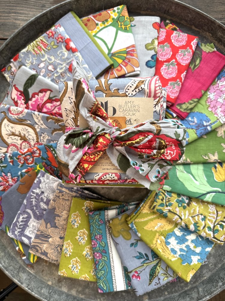 Collection of colorful fabric swatches arranged on a metal tray.