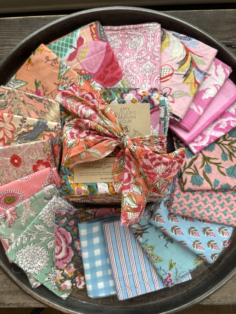 Collection of colorful fabric swatches arranged in a circular pattern on a wooden surface.