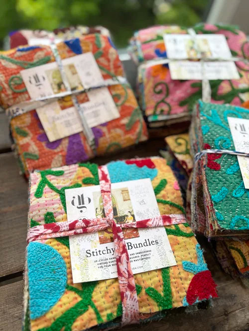Colorful fabric bundles with labels on a wooden surface