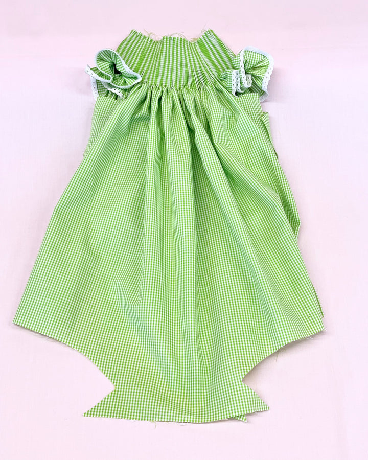 Green checkered dress with ruffled straps on a light pink background