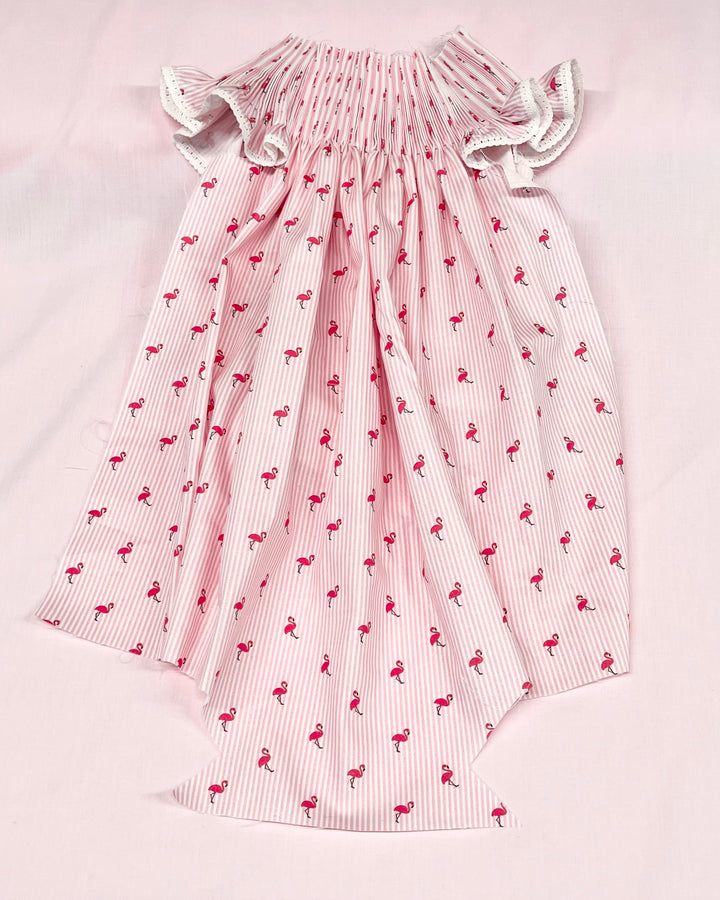 Pink dress with flamingo pattern on a light pink background