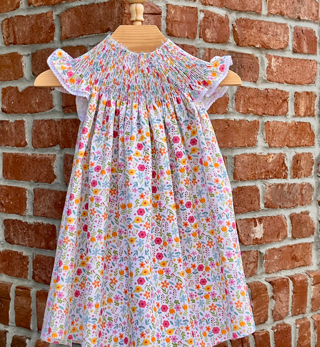 Floral dress on a mannequin against a brick wall