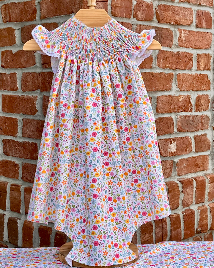 Floral dress on a mannequin against a brick wall