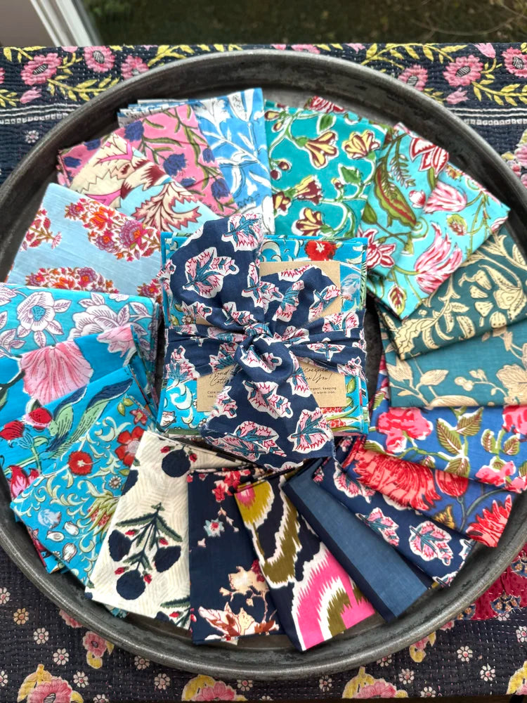 Collection of floral fabric squares in a circular arrangement on a black tray.