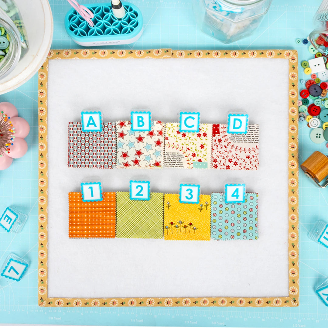 Colorful fabric swatches arranged in a grid on a light blue background with various craft supplies.