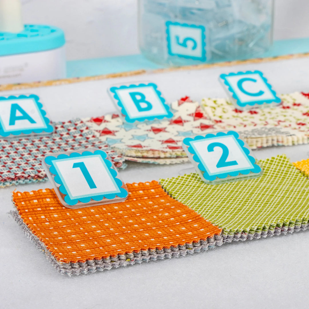 Colorful play mats with letter and number markers on a light surface.