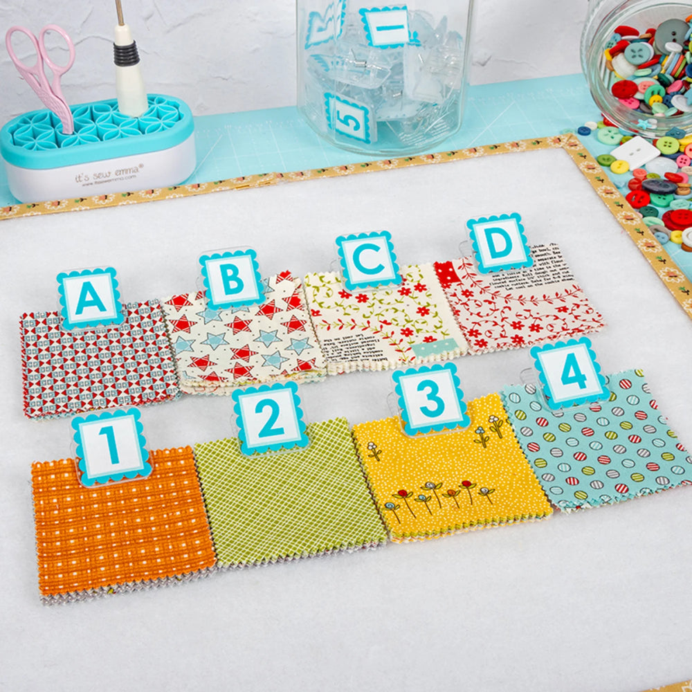 Colorful fabric swatches with letters and numbers on a white surface.