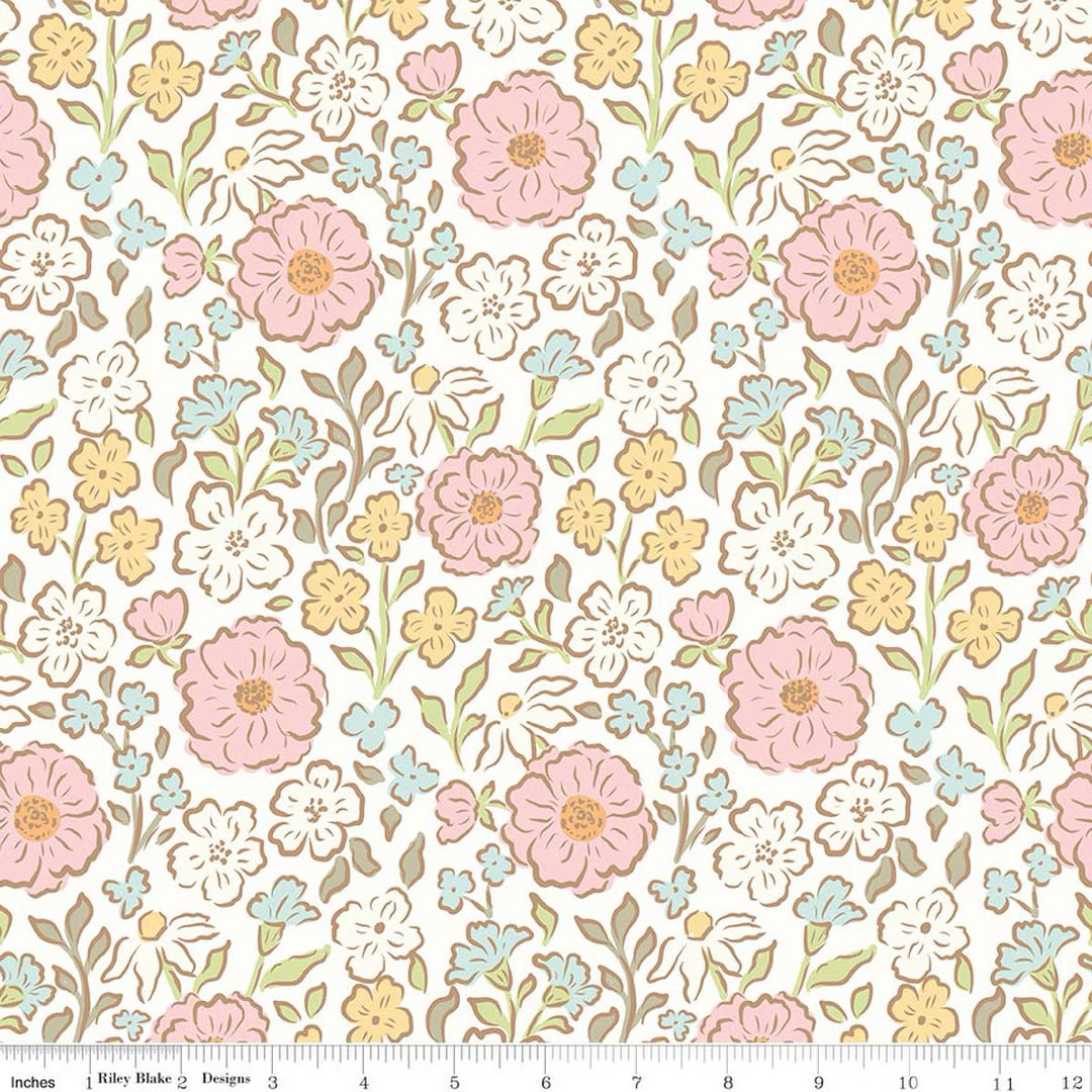 Fabric swatch of pink, yellow, cream and blue flowers on a cream background. There is a ruler on the bottom for scale. 